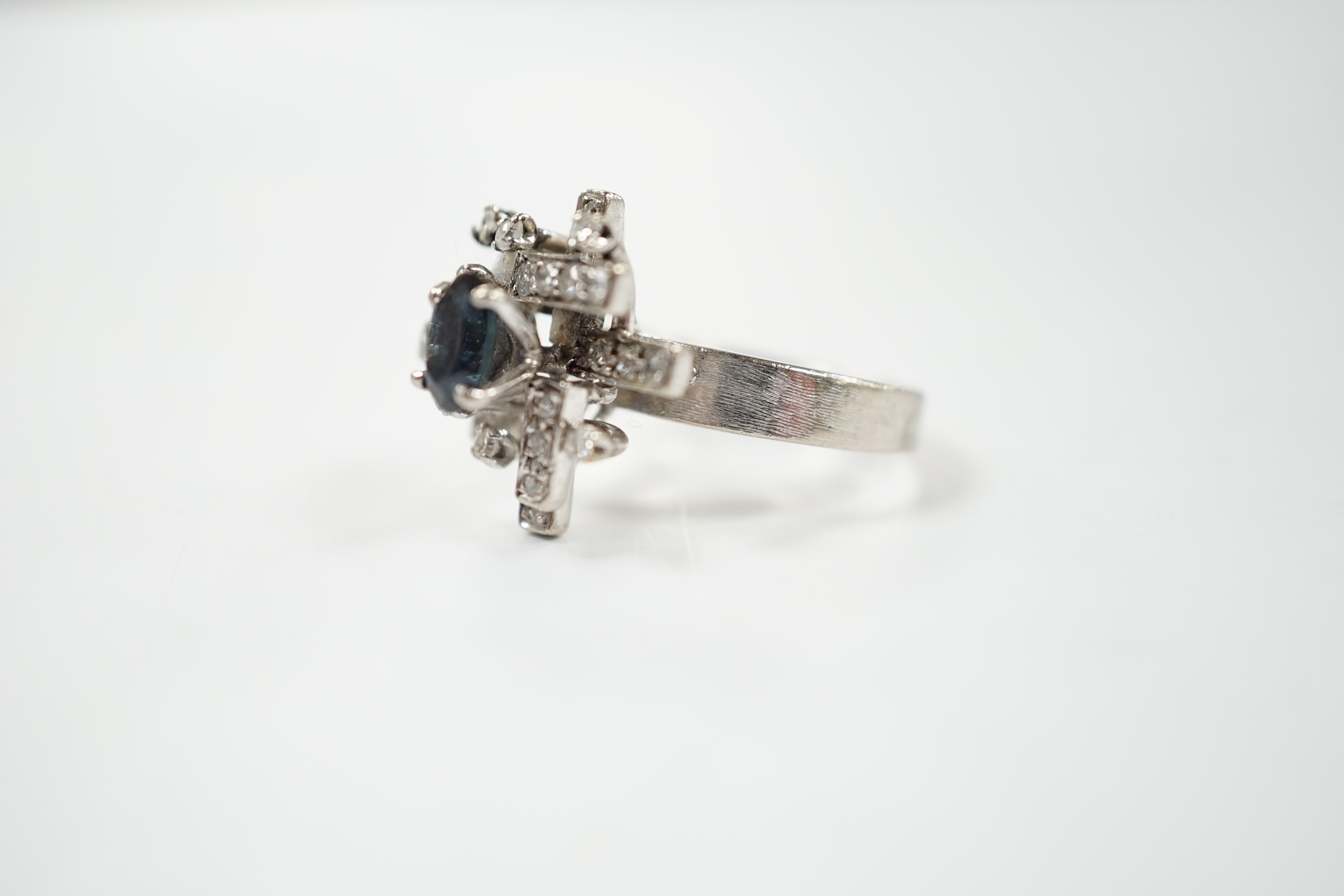 A modern 18k white metal, sapphire and diamond set modernist ring, size K/L, gross weight 6.1 grams.